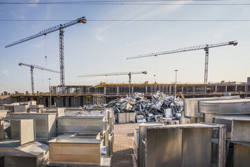 Construction site of shopping mall with many cranes on a background of blue sky with cirrus clouds. Kyiv. Obolon