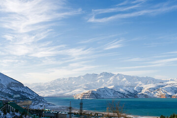 Charvak mountain lake in Uzbekistan on a snowy frosty day, surrounded by the Tien Shan mountains