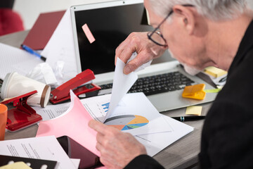 Disorganized businessman looking for documents