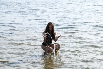 young girl splashing water in the river