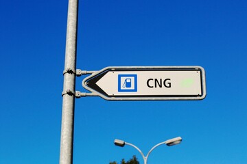 Fototapeta premium Sign shows direction gas station with CNG. Traffic sign indicating a CNG gas station. Sign for gas station with CNG natural gas.
