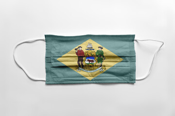 Face mask with Delaware flag printed, on white background, isolated