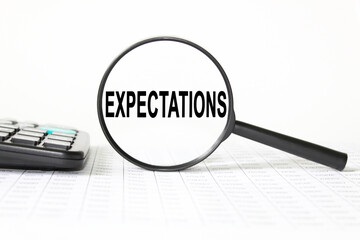 words EXPECTATIONS in a magnifying glass on a white background. business concept
