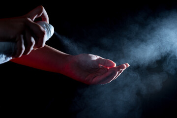 Caucasian woman wipes her hands with an alcohol-based hand-washing spray.