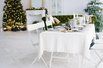 A homely place with Christmas decorations, a Christmas tree and a good table for a large family. Christmas or New year interior.