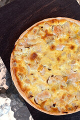 Round meat quiche pie with veal meat on dark background.