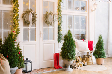 The white private house is decorated with small Christmas trees and lanterns, a bag of gifts. A...