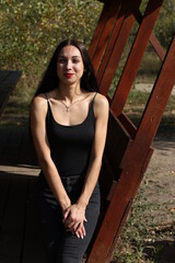 young brunette sitting in a wooden gazebo