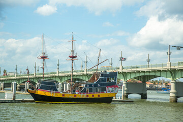 A tall ship replica with the Bridge of Lions in the background.  It is a double-leaf bascule bridge...