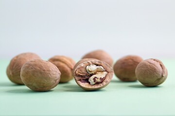 photo of group of Walnut nuts peeled and whole, closed and half opened on green and white background