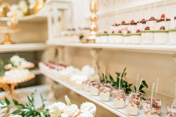 Dessert table for a party. Ombre cake, cupcakes, sweetness and flowers
