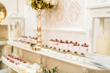 Dessert table for a party. Ombre cake, cupcakes, sweetness and flowers