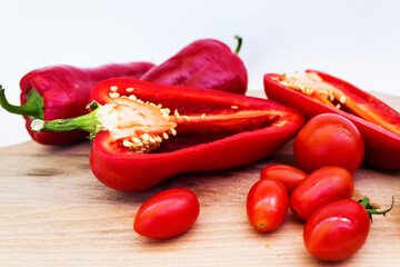red pepper, pepper in cut, cherry tomatoes on white background