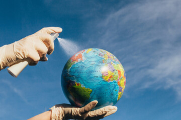 Global health and hygiene standards for a respiratory disease pandemic - antiseptic spraying on the globe of planet Earth - covid 2019