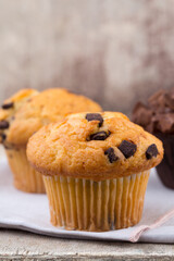 Homemade muffins with chocolate, vintage background.