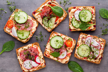 Sandwiches with cream cheese, vegetables and salami.