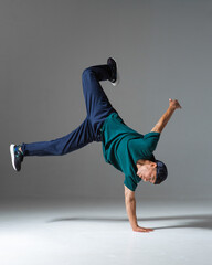 Cool guy breakdancer dance on the floor isolated on gray background. Breakdance lessons