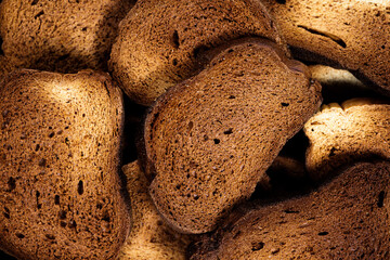 The texture of toasted pieces of bread. Croutons on a white background. Dark dry bread.