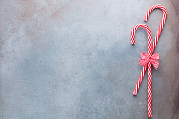 Christmas candy cane lied on blue background. Flat lay and top view.