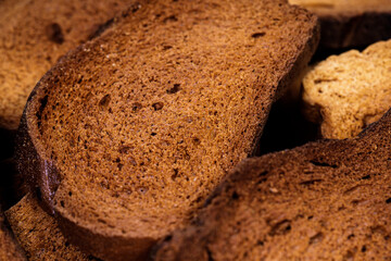 The texture of toasted pieces of bread. Croutons on a white background. Dark dry bread.