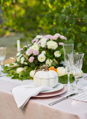 Table setting with beautiful autumn decorand with white mini pumpkins and crystal glasses for Thanksgiving Day or Halloween
