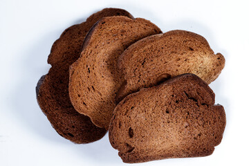 The texture of toasted pieces of bread. Croutons on a white background. Dark dry bread.