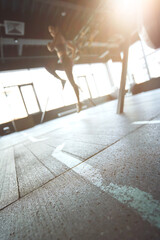 Sport training concept. Vertical shot of athletic woman in sportswear working out at industrial gym, focus on the floor