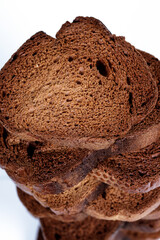 The texture of toasted pieces of bread. Croutons on a white background. Dark dry bread.