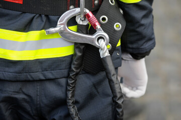 Details with the carabiner and harness of a firefighter.