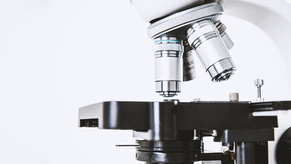 Using a biological microscope. Close-up of the microscope lens. Scientific research concept, using a microscope. Medical examinations, searching for bacteria, diseases, blood tests.