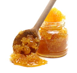 Honey in honeycomb with glass jar and wooden spoon isolated on white background
