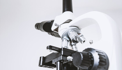 Using a biological microscope. Close-up of the microscope lens. Scientific research concept, using a microscope. Medical examinations, searching for bacteria, diseases, blood tests.