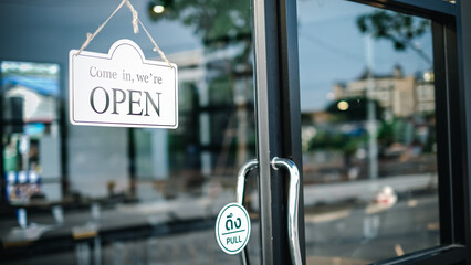 Come in we're open sign, on cafe or restaurant hang on door at entrance. Vintage color tone style.