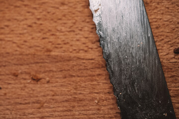 Closeup Macro of Used bread knife on breadboard with bread crumbs