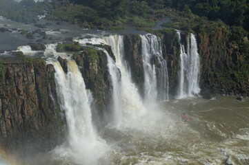 Fototapeta premium Rainbows over the mighty and powerful Iguzu (Iguacu) Waterfalls between Brazil and Argentina