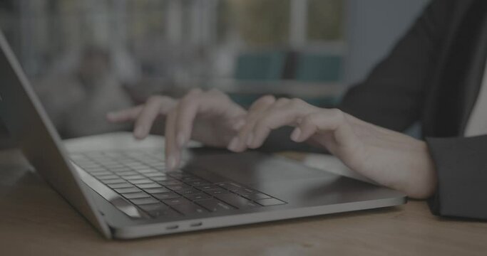 Close-up of female hands typing laptop keyboard at desk. Young unrecognizable business woman using laptop computer in caffee shop.