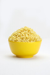 Indian snaxks roasted moong dal in yellow bowl in white background.