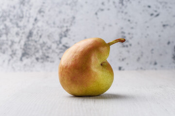 Trendy ugly organic fruits -one green pears on the table with copy space for text.