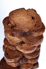 The texture of toasted pieces of bread. Croutons on a white background. Dark dry bread.
