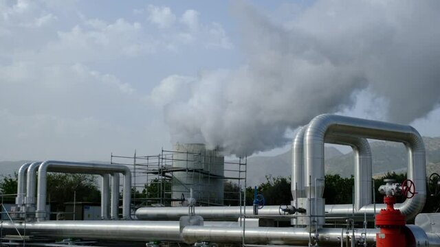 Geothermal station with steam and pipes in the rainforest. Billowing steam from smoke stack filling sky, super slow motion close up. Buharkent, Turkey