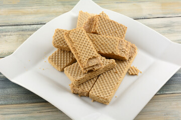 Broken wafer cookies damaged by poor packaging on dessert plate