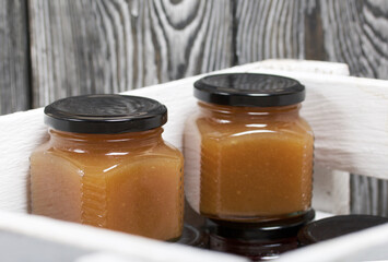 Fruit jam in jars. Stands in a wooden box painted white.