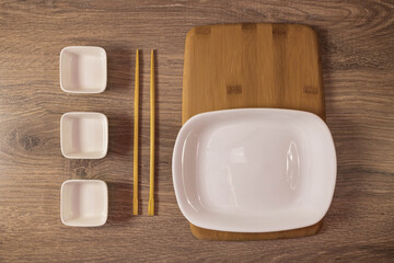 Sushi set is served on a plate, Board on the background. Traditional Japanese cuisine, sushi rolls close-up. Top view of assorted sushi rolls on white plate close-up.