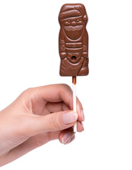 Chocolate santa claus on a stick in a female hand. Delicious festive Christmas sweets