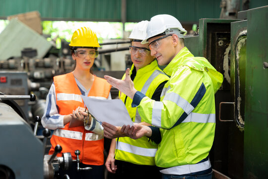 Selective Focus. Supervisor, Technician worker working in heavy Industry manufacturing factory on business day. Industrial engineers have to consult with colleagues. Workplace gender equality concept