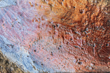 A relief stone, painted in dark yellow, dark blue, dark red. Can be used as a background.