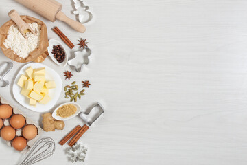 Ingredients for baking Christmas gingerbread cookies top view on white wooden background.