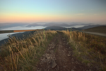 Marked hiking trail in the Bieszczady Mountains leading above the clouds