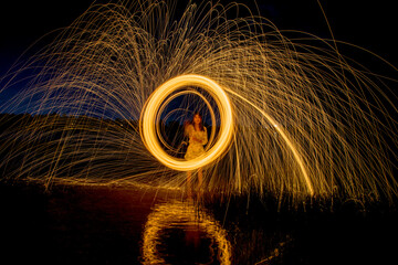 Burning Steel Wool spinning, Trajectories of burning sparks on the surface of water lake at the...