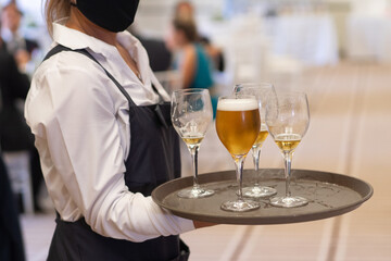 waitress holds tray with beer glasses